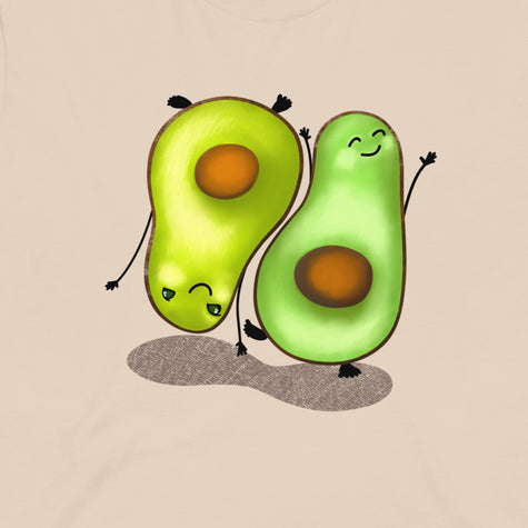 Thumbnail close-up of the Avocado Harmony graphic tee in cream white, showing two cute avocado characters doing mirrored poses, one upright and one hand-standing.