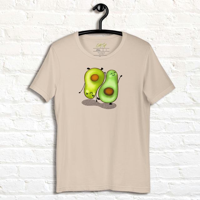 Cream white Avocado Yoga Tee displayed on a hanger, featuring two cute avocados performing yoga poses with expressive faces and playful movement.