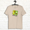 Cream white Avocado Yoga Tee displayed on a hanger, featuring two cute avocados performing yoga poses with expressive faces and playful movement.