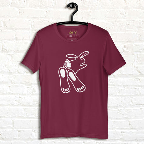 Chill Bunny Line Art Tee hanging against a white brick wall, showing the relaxed rabbit outline on a maroon shirt.