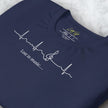 Close-up detail of a folded navy Lost in Music Tee, highlighting the clean white heartbeat‑to‑treble‑clef line art.