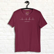 Burgundy Heartbeat Music Tee displayed on a hanger showing the minimalist ECG‑inspired heartbeat line transitioning into a treble clef with ‘Lost in music…,’ printed in bright white on breathable cotton