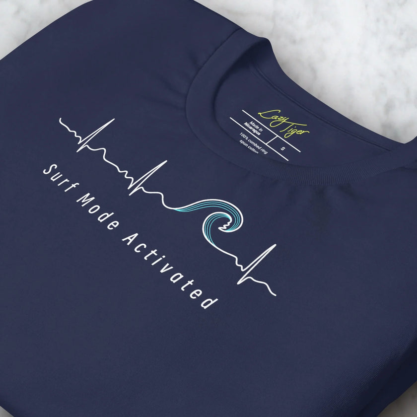 Close-up detail of a folded navy Surf Mode Activated Tee, highlighting the clean white surf‑wave line art and smooth print texture.