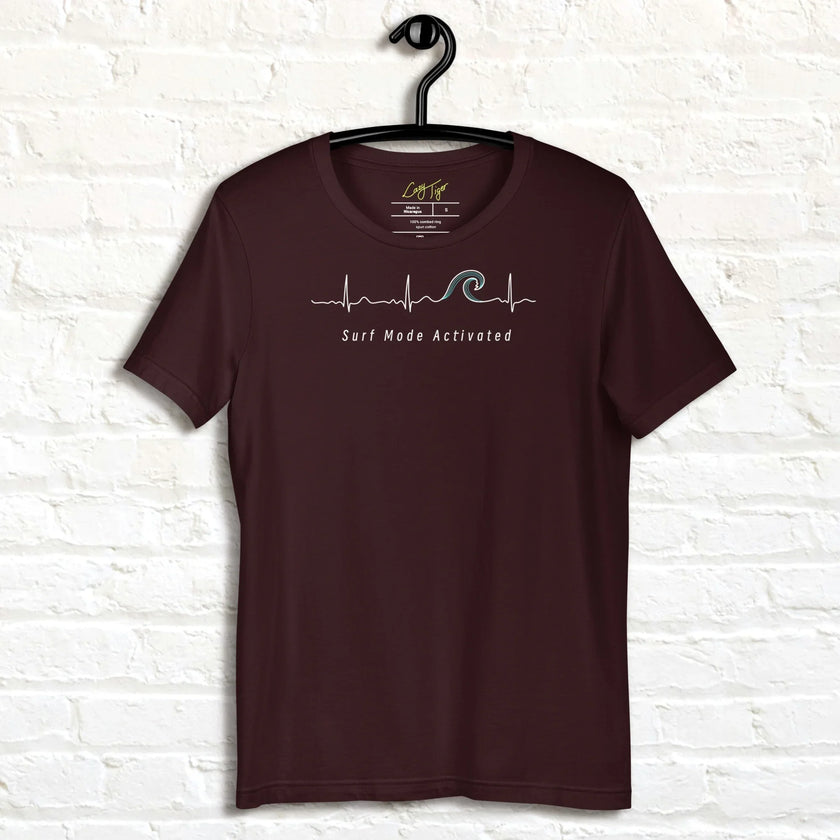 Dark brown Surf Mode Activated Tee displayed on a hanger, featuring the minimalist surf‑wave line art and relaxed beach‑inspired lettering.