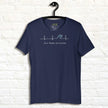 Navy Surf Mode Activated Tee hanging against a white wall, showing the minimalist heartbeat line transforming into a surf wave with the ‘Surf Mode Activated’ script.