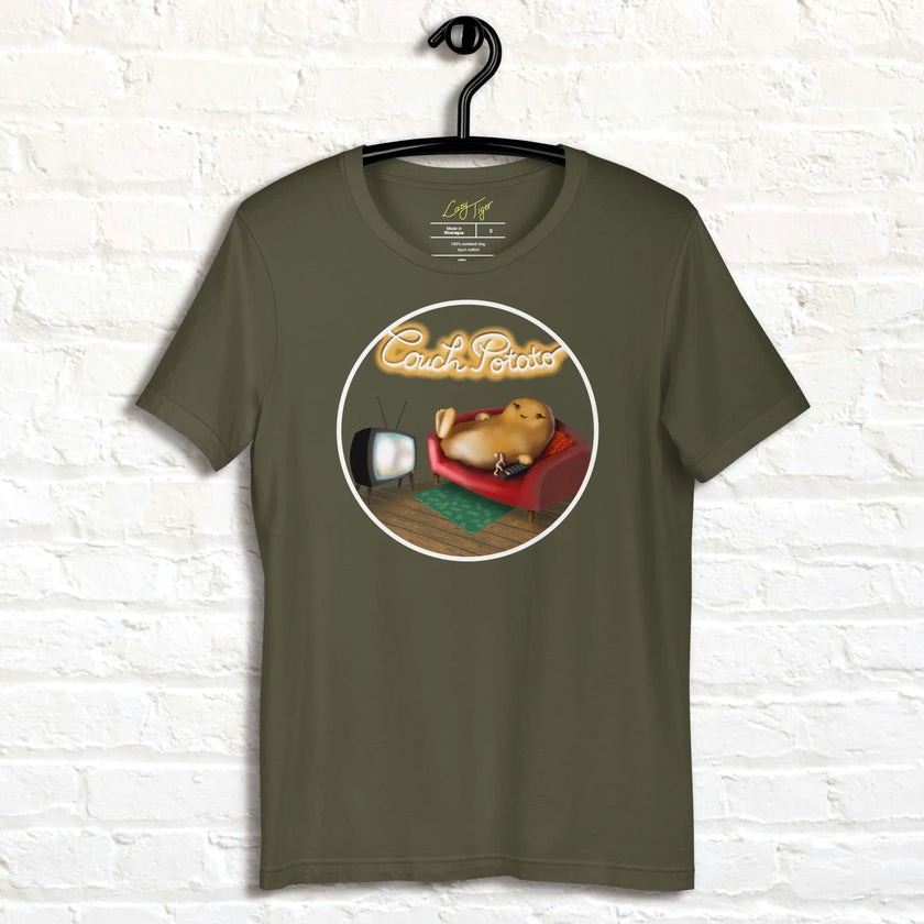 Olive green Lazy Potato Tee displayed on a hanger, showing the relaxed potato on a couch with glowing script and cozy living‑room details.