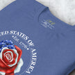 Close-up detail of a folded vintage blue Liberty Rose Tee, highlighting the red‑white‑and‑blue rose illustration and surrounding anniversary text.