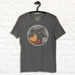 Dark graphite T‑shirt on hanger with cartoon velociraptor eating pizza, humorous dino graphic tee for men and women.