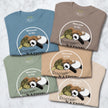Five folded Procrasti‑NATION tees in sage, denim blue, taupe, beige, and cream showing the sleepy sloth, panda, and turtle design for cute animal shirt collections.