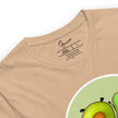 Detail shot of the two avocados and a brand label on a beige tee