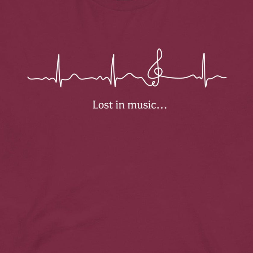 Closeup of the Heartbeat Music Tee in burgundy featuring an ECG‑style heartbeat line flowing into a treble clef with the text ‘Lost in music…,’ printed in crisp white on burgundy red cotton fabric.