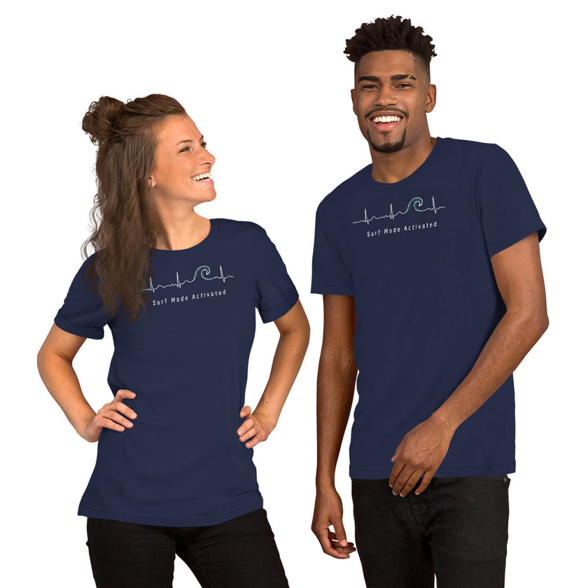 Two models wearing the navy Heartbeat Surf Tee with the ECG‑style heartbeat‑to‑wave surf graphic and ‘Surf Mode Activated’ text, styled in a relaxed coastal, surf‑inspired look
