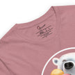 Detail shot of a joyful polar bear graphic and a brand label on a rosewood tee