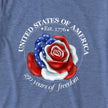Closeup of a rose illustration with red, white, and blue petals and white stars, styled like the American flag, printed on a vintage navy tee