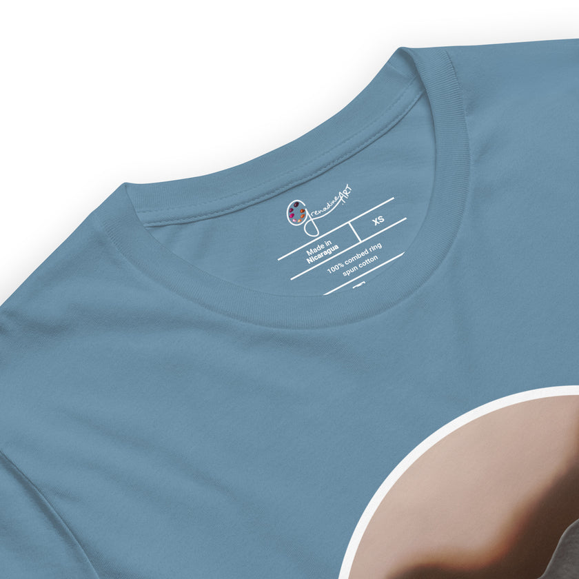Detail shot of a dinosaur print and brand label on a denim blue tee