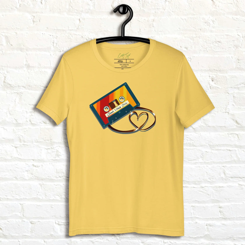 Bright yellow Retro Vibes Cassette Tee displayed on a hanger, featuring the bold vintage cassette and heart‑shaped tape design.