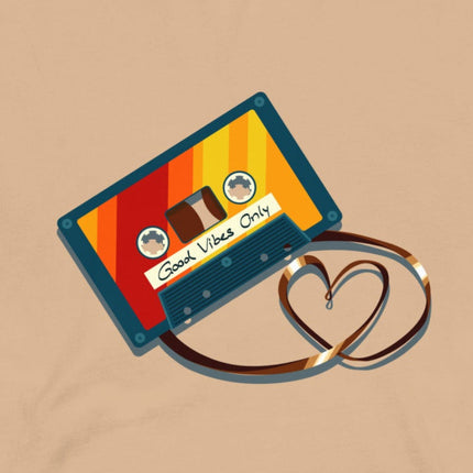 Closeup of a retro cassette in bold vintage colors with its tape forming a heart shape, printed on a beige tee
